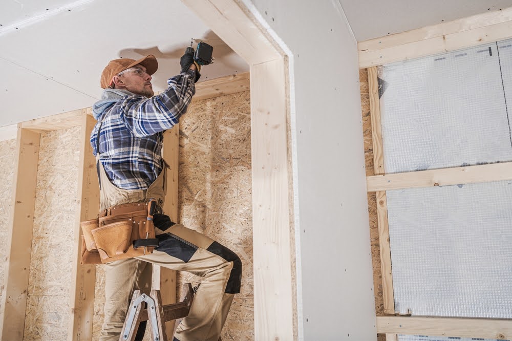 A contractor installing mold-resistant materials in a house under construction.