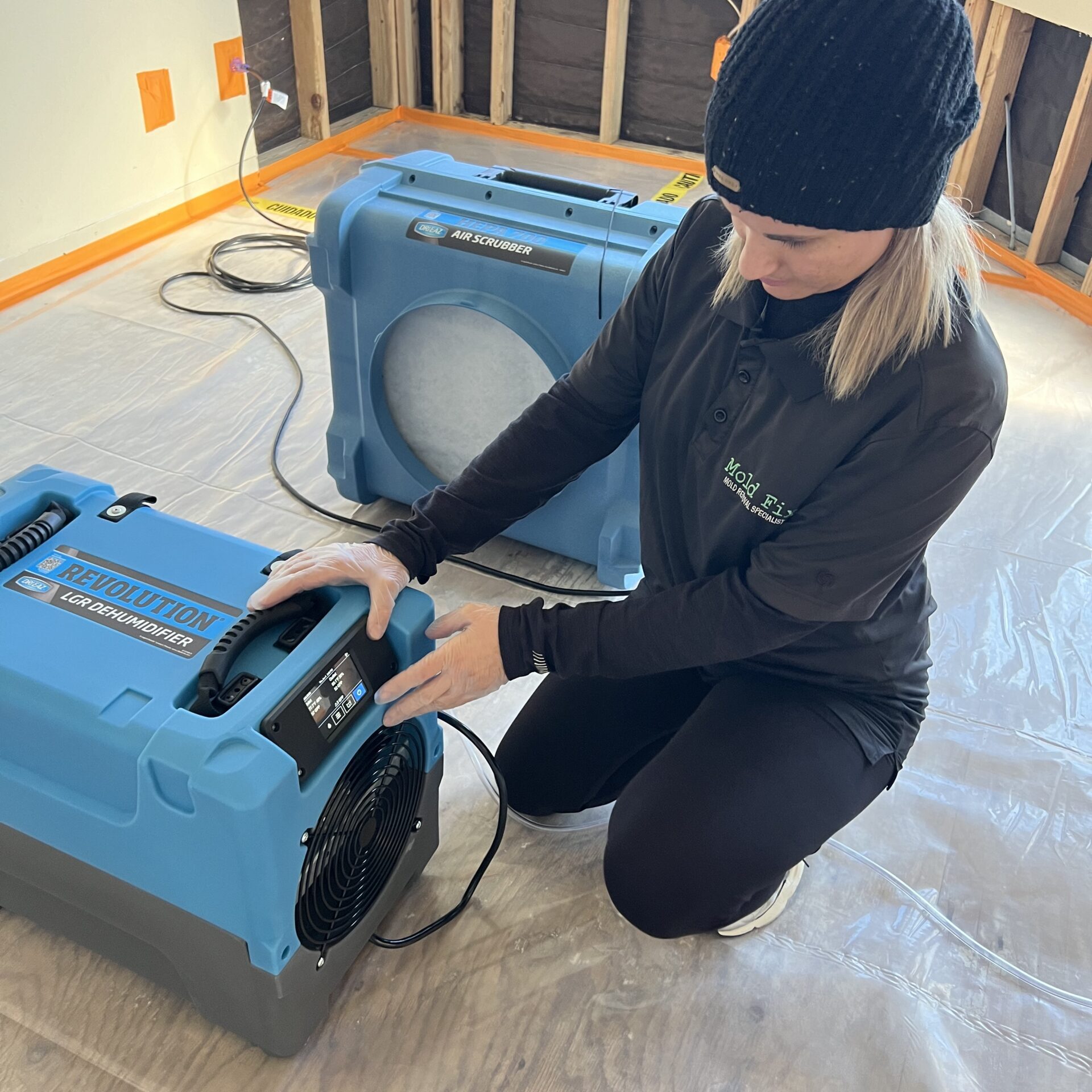 Technician adjusting industrial dehumidifier during water damage services in Orange County