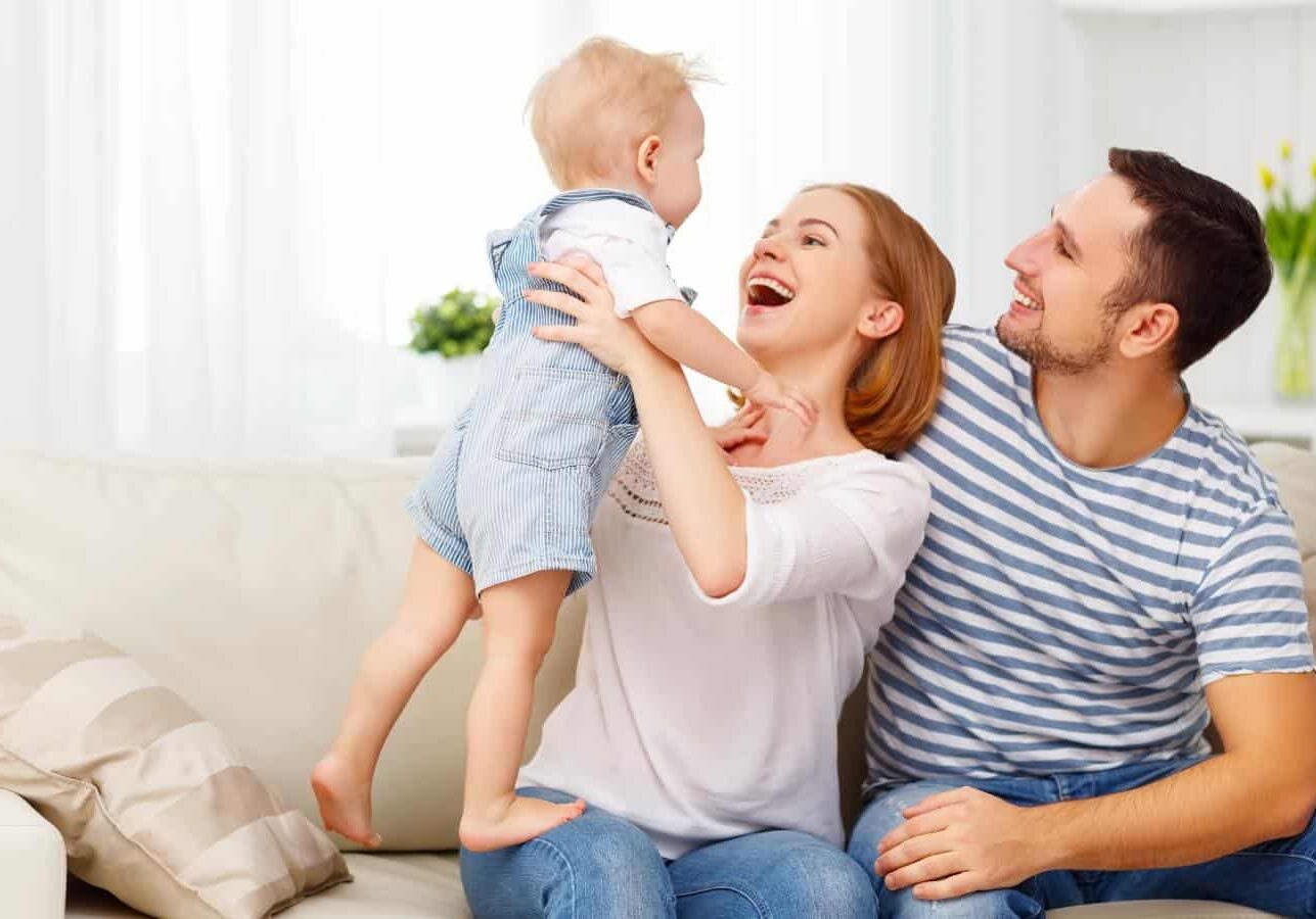 Happy Smiling Couple playing with their baby