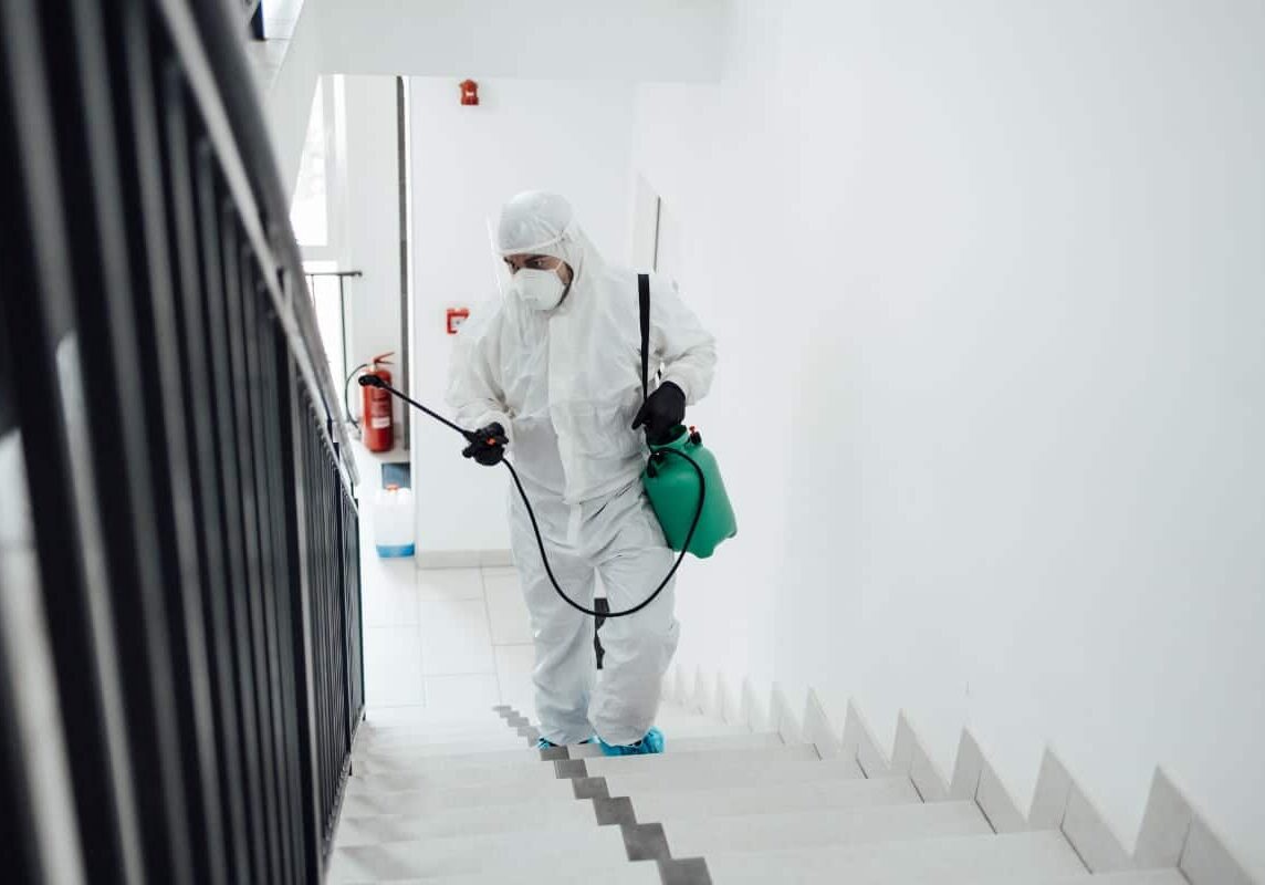 Man Cleaning stairs using disinfection spray